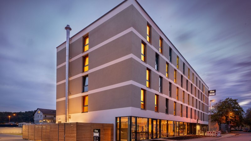 Moderne Hotelau&szlig;enfassade bei D&auml;mmerung, beleuchtete Fenster, Schild mit 'the niu'., &copy; Novum Hospitality