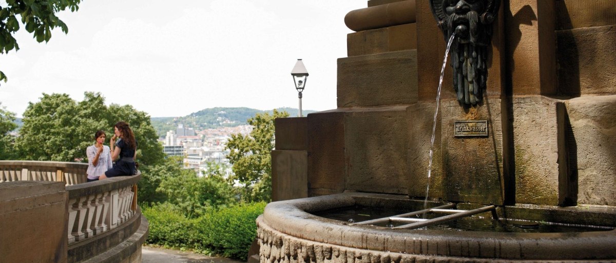 Der Galateabrunnen am Eugensplatz in Stuttgart. Zwei Personen sitzen auf einer Balustrade, im Hintergrund die Stadt und grüne Hügel., © Stuttgart-Marketing GmbH Christoph Düpper Der Galateabrunnen am Eugensplatz in Stuttgart. Zwei Personen sitzen auf einer Balustrade, im Hintergrund die Stadt und grüne Hügel., © Stuttgart-Marketing GmbH Christoph Düpper