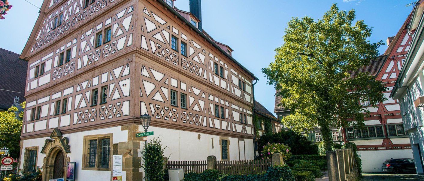 Fachwerkhaus in Bietigheim-Bissingen, umgeben von Bäumen und einem gepflegten Garten. Der Himmel ist klar und blau., © Stuttgart-Marketing GmbH, Sarah Schmid Fachwerkhaus in Bietigheim-Bissingen, umgeben von Bäumen und einem gepflegten Garten. Der Himmel ist klar und blau., © Stuttgart-Marketing GmbH, Sarah Schmid