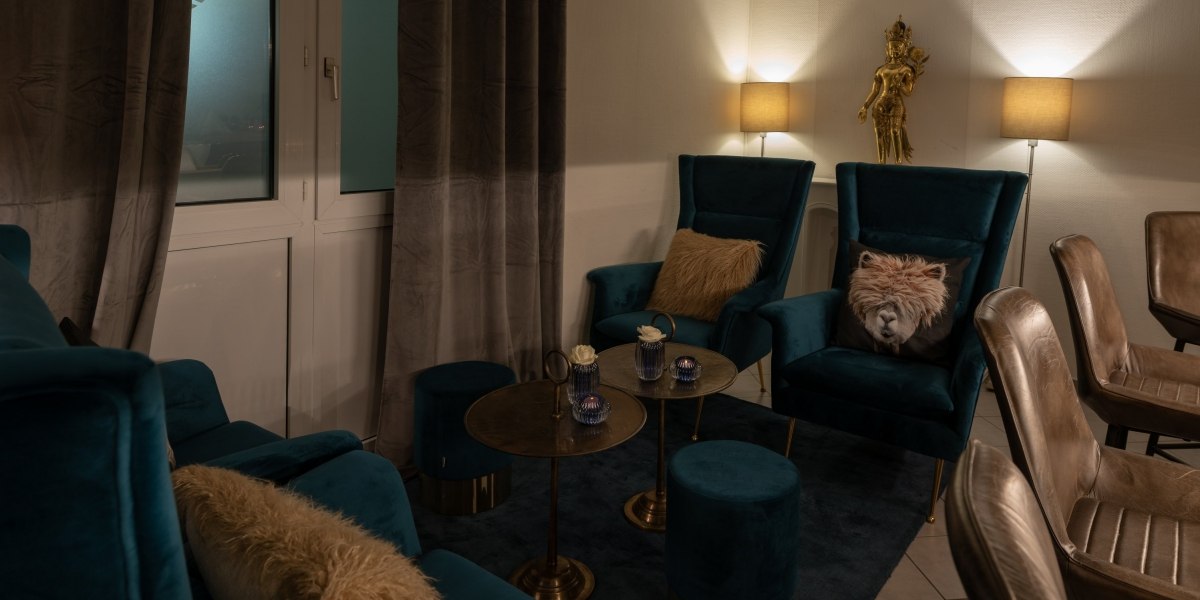 Gemütliche Bar-Lounge mit blauen Sesseln, goldenen Tischen und gedämpfter Beleuchtung. Dekorative Kissen und eine goldene Statue ergänzen das Ambiente., © Hotel Princess