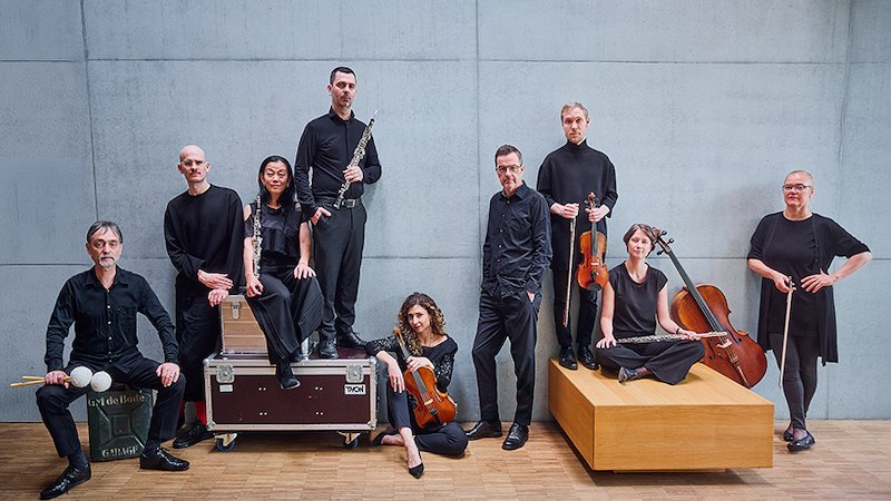 Acht Musiker in schwarzer Kleidung posieren mit Instrumenten vor einer grauen Wand. Sie stehen und sitzen auf Kisten und Podesten., © Stadt Leonberg - Amt für Kultur und Sport