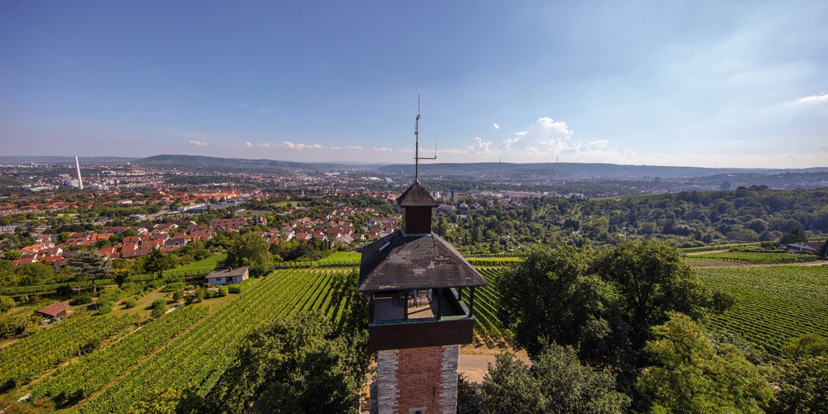 Aussichtsturm Burgholzhof in Stuttgart, umgeben von Weinbergen, mit Blick auf die Stadt und Hügel im Hintergrund unter klarem Himmel., © Stuttgart-Marketing GmbH