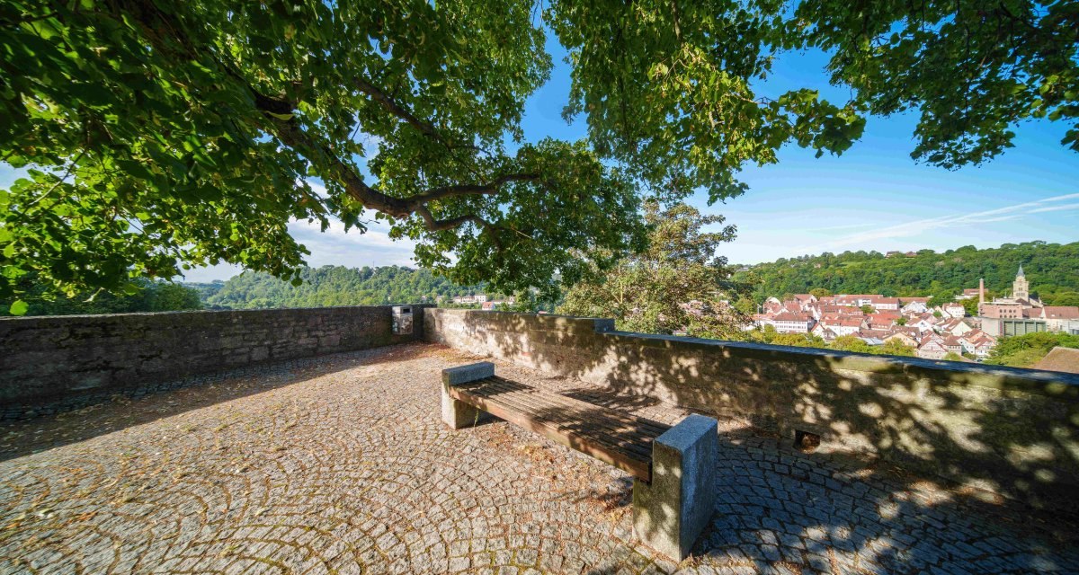 Ein Aussichtspunkt mit Bank und gepflastertem Boden, umgeben von B&auml;umen, bietet einen Blick auf die Stadt Schw&auml;bisch Hall und ihre Umgebung., &copy; Michael K&uuml;hneisen