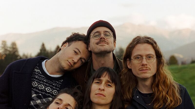 F&uuml;nf Personen posieren eng beieinander vor einer malerischen Berglandschaft. Sie wirken entspannt und freundlich., &copy; Scala Kultur Live gGmbH