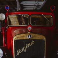 Ein rotes, historisches Feuerwehrfahrzeug der Marke Magirus im Feuerwehrmuseum Schwäbisch Hall, mit blauen Rundlichtern und einem goldenen Kühlergrill., © Nico Kurth Ein rotes, historisches Feuerwehrfahrzeug der Marke Magirus im Feuerwehrmuseum Schwäbisch Hall, mit blauen Rundlichtern und einem goldenen Kühlergrill., © Nico Kurth