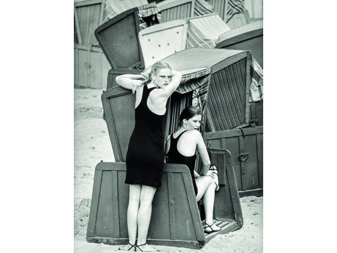 Zwei Frauen in Badeanz&uuml;gen posieren in und neben Strandk&ouml;rben an einem Sandstrand. Die Szene wirkt nostalgisch und sommerlich., &copy; Kunsthalle G&ouml;ppingen