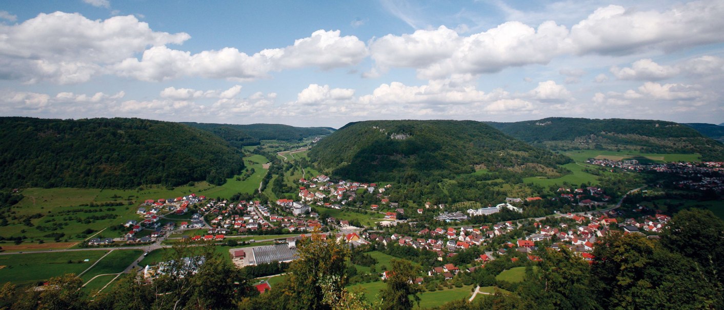 Panoramablick auf Bad Ditzenbach, umgeben von grünen Hügeln und Wäldern unter einem bewölkten Himmel., © Stuttgart-Marketing GmbH Panoramablick auf Bad Ditzenbach, umgeben von grünen Hügeln und Wäldern unter einem bewölkten Himmel., © Stuttgart-Marketing GmbH