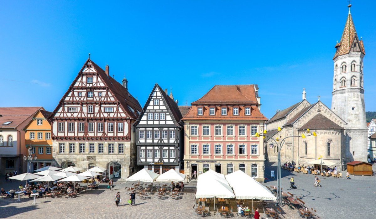 Historische Fachwerkhäuser und eine Kirche am Marktplatz von Schwäbisch Gmünd bei sonnigem Wetter. Menschen sitzen unter Sonnenschirmen., © T&M GmbH Schwäbisch Gmünd Historische Fachwerkhäuser und eine Kirche am Marktplatz von Schwäbisch Gmünd bei sonnigem Wetter. Menschen sitzen unter Sonnenschirmen., © T&M GmbH Schwäbisch Gmünd