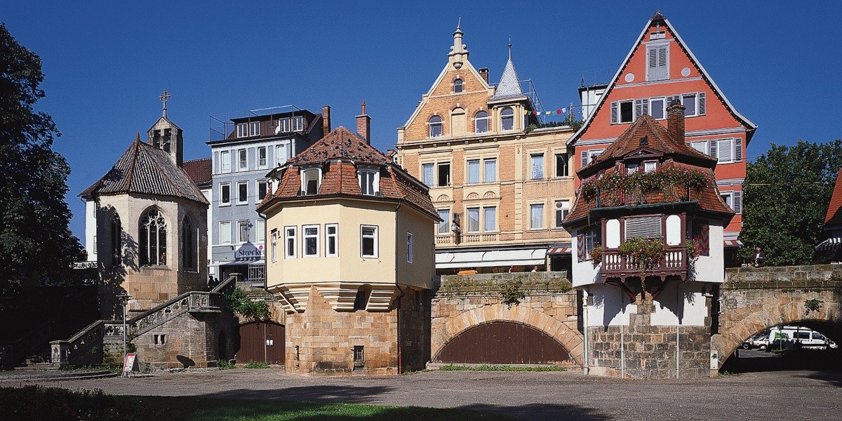 Historische Gebäude in Esslingen mit Fachwerk und Brücke, darunter ein gelbes und ein rotes Haus. Im Hintergrund moderne Gebäude., © Stuttgart-Marketing GmbH Historische Gebäude in Esslingen mit Fachwerk und Brücke, darunter ein gelbes und ein rotes Haus. Im Hintergrund moderne Gebäude., © Stuttgart-Marketing GmbH