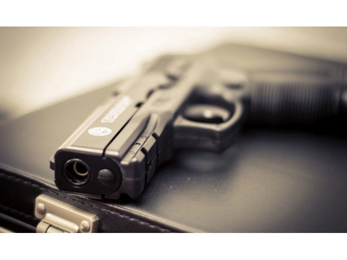 Eine schwarze Pistole liegt auf einem schwarzen Aktenkoffer. Die Szene wirkt geheimnisvoll und professionell., © TeamEscape Stuttgart Eine schwarze Pistole liegt auf einem schwarzen Aktenkoffer. Die Szene wirkt geheimnisvoll und professionell., © TeamEscape Stuttgart