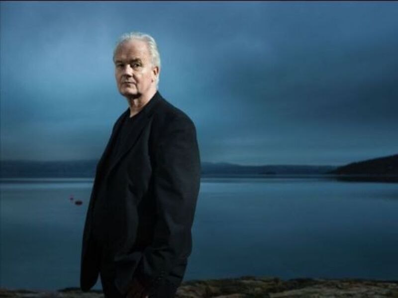 Ein Mann in dunkler Kleidung steht vor einem ruhigen See. Der Himmel ist bewölkt und die Atmosphäre wirkt ruhig und nachdenklich., © Jazzclub Schwäbisch Hall e.V.