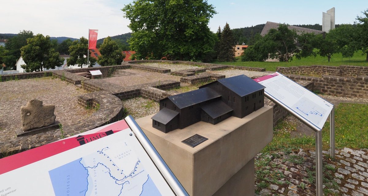 Arch&auml;ologische St&auml;tte mit Infotafeln und einem Modell eines Geb&auml;udes. Im Hintergrund sind B&auml;ume und moderne Geb&auml;ude zu sehen., &copy; T&M GmbH Schw&auml;bisch Gm&uuml;nd