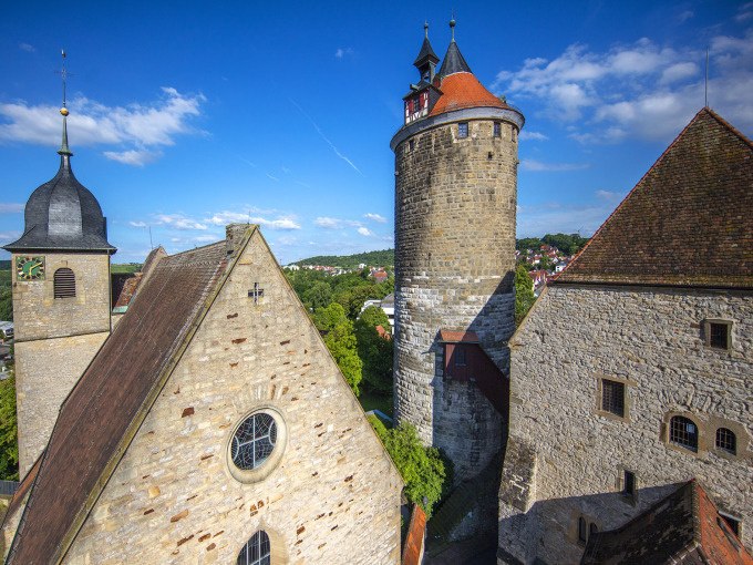 Historische Gebäude in Besigheim mit einem markanten Turm und alten Steinhäusern. Der blaue Himmel und die grüne Landschaft ergänzen die mittelalterliche Szenerie., © Stadt Besigheim Historische Gebäude in Besigheim mit einem markanten Turm und alten Steinhäusern. Der blaue Himmel und die grüne Landschaft ergänzen die mittelalterliche Szenerie., © Stadt Besigheim