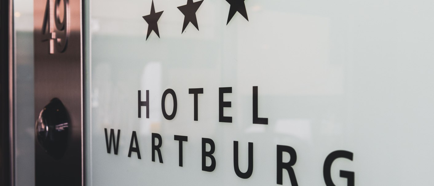 Eingangsschild des Hotel Wartburg mit drei Sternen und der Nummer 49., © TOMAS