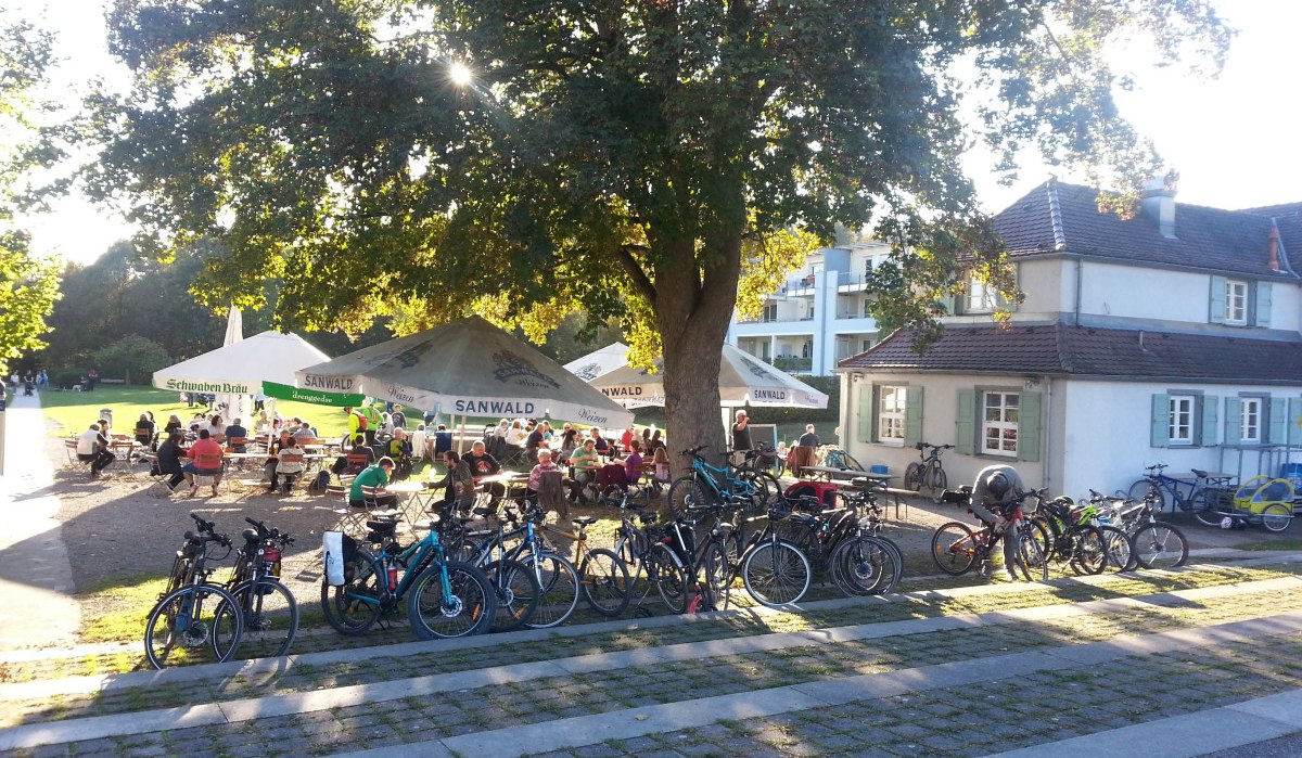 Ein Biergarten im Freien mit vielen Fahrrädern im Vordergrund. Menschen sitzen unter großen Bäumen und Sonnenschirmen, genießen das Wetter., © Kulturamt Plochingen Ein Biergarten im Freien mit vielen Fahrrädern im Vordergrund. Menschen sitzen unter großen Bäumen und Sonnenschirmen, genießen das Wetter., © Kulturamt Plochingen