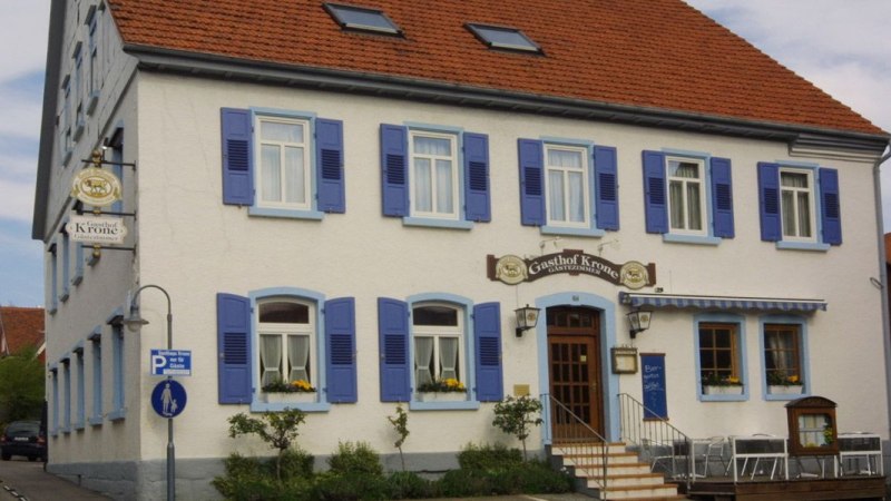 Ein traditionelles Gasthaus mit blauen Fensterläden und einem Schild mit der Aufschrift 'Gasthof Krone'., © Gasthof zur Krone Ein traditionelles Gasthaus mit blauen Fensterläden und einem Schild mit der Aufschrift 'Gasthof Krone'., © Gasthof zur Krone