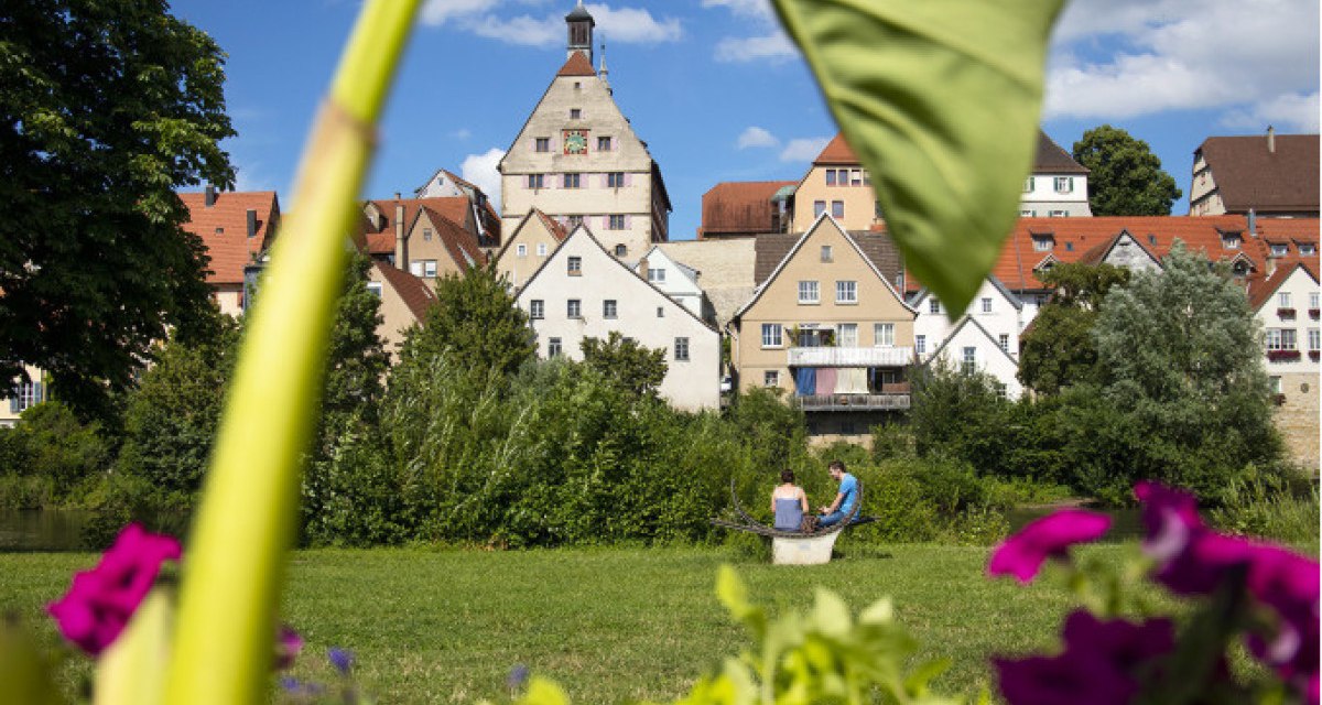 Historische Altstadt von Besigheim mit Fachwerkhäusern, umgeben von grüner Natur und bunten Blumen im Vordergrund., © Stadt Besigheim