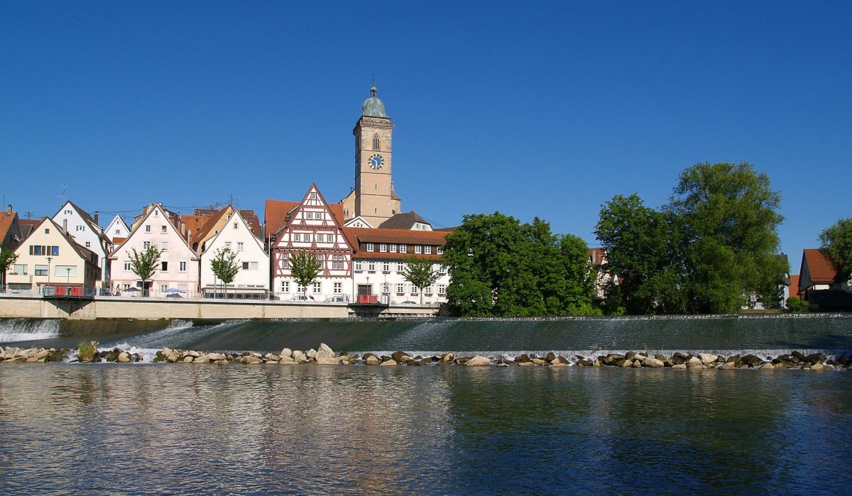 Fachwerkhäuser und ein Kirchturm in Nürtingen spiegeln sich im Fluss unter blauem Himmel wider., © Stadt Nürtingen Fachwerkhäuser und ein Kirchturm in Nürtingen spiegeln sich im Fluss unter blauem Himmel wider., © Stadt Nürtingen