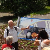 Ein Mann zeigt einer Gruppe ein Schild &uuml;ber Venus auf dem Johannes-Kepler-Planetenweg. Die Gruppe h&ouml;rt aufmerksam zu., &copy; Natur.Nah. Sch&ouml;nbuch & Heckeng&auml;u