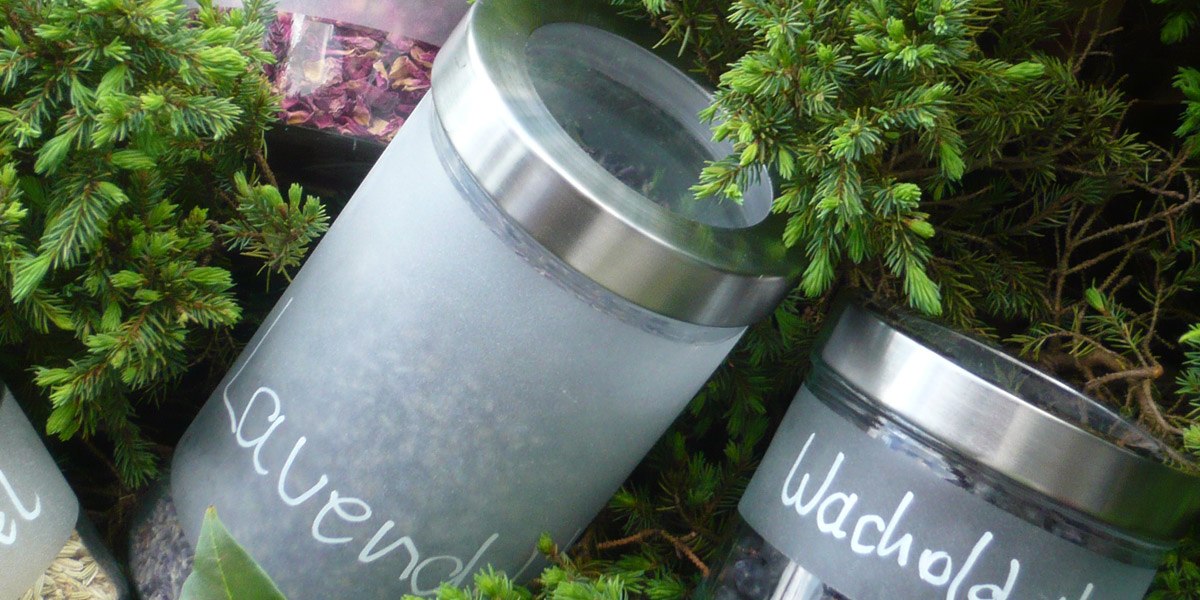 Zwei Glasbehälter mit Lavendel und Wacholder, umgeben von grünen Zweigen, vermitteln ein Gefühl von Natur und Entspannung., © Hotel Hochwald