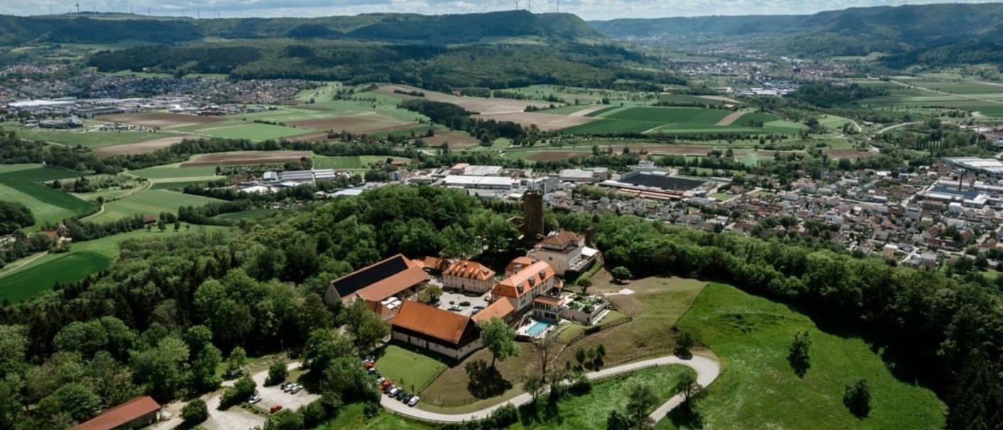 Luftaufnahme der Burg Staufeneck, umgeben von grünen Feldern und Wäldern, mit Blick auf eine Stadt im Hintergrund., © Christian Prerauer Luftaufnahme der Burg Staufeneck, umgeben von grünen Feldern und Wäldern, mit Blick auf eine Stadt im Hintergrund., © Christian Prerauer