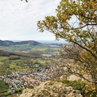 Panoramablick vom Beurener Fels über ein grünes Tal mit einem Dorf und bewaldeten Hügeln im Hintergrund. Ein Wanderer steht am Rand des Felsens., © Stuttgart-Marketing GmbH, Sarah Schmid Panoramablick vom Beurener Fels über ein grünes Tal mit einem Dorf und bewaldeten Hügeln im Hintergrund. Ein Wanderer steht am Rand des Felsens., © Stuttgart-Marketing GmbH, Sarah Schmid