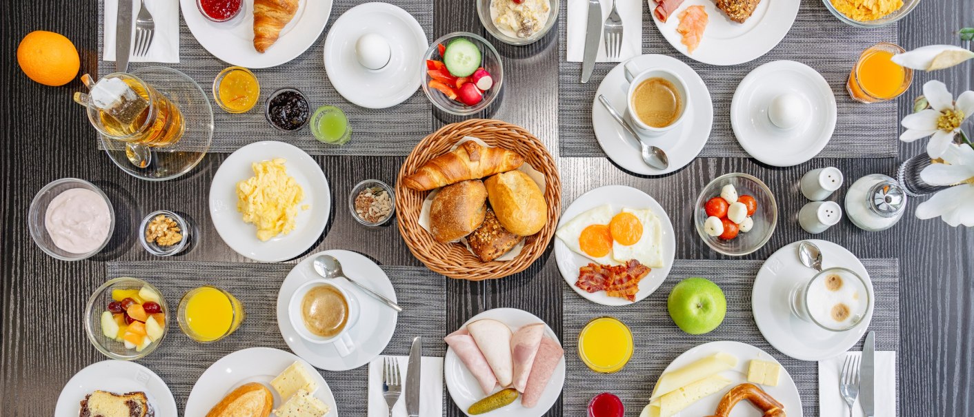 Ein reich gedeckter Frühstückstisch mit Croissants, Brötchen, Eiern, Aufschnitt, Käse, Obst, Joghurt und verschiedenen Getränken., © Plaza Residence Stuttgart-Ditzingen Ein reich gedeckter Frühstückstisch mit Croissants, Brötchen, Eiern, Aufschnitt, Käse, Obst, Joghurt und verschiedenen Getränken., © Plaza Residence Stuttgart-Ditzingen