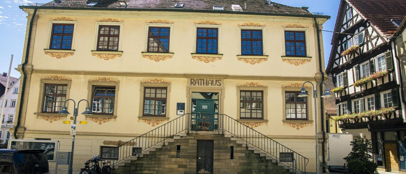 Das historische Rathaus von Vaihingen an der Enz mit Treppe und verzierten Fenstern, daneben ein Fachwerkhaus mit Blumenkästen., © Stuttgart-Marketing GmbH, Sarah Schmid
