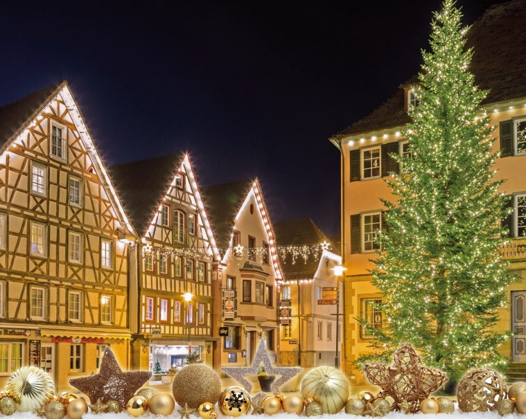 Beleuchtete Fachwerkhäuser und ein großer, geschmückter Weihnachtsbaum bei Nacht auf dem Murrhardter Weihnachtsmarkt., © Stadt Murrhardt