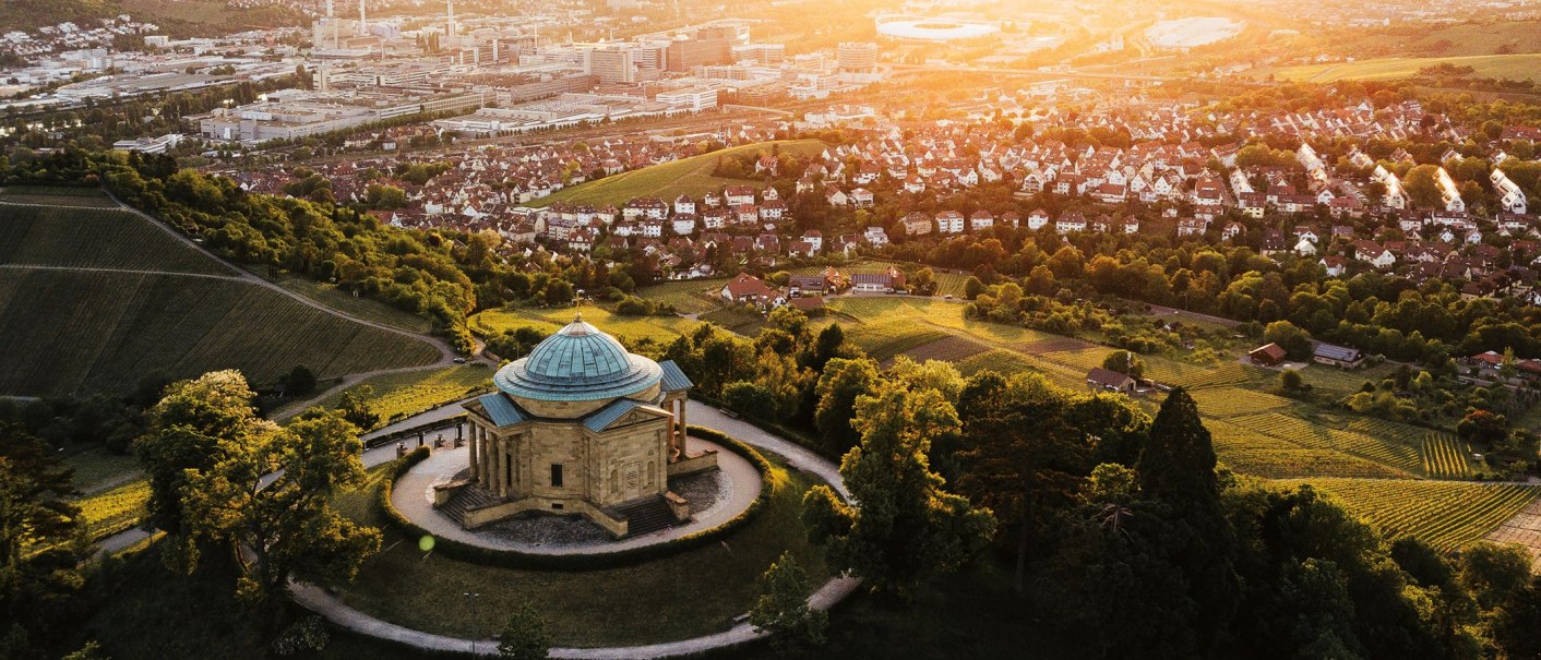 Luftaufnahme der Grabkapelle auf dem Württemberg in Stuttgart, umgeben von Weinbergen und Stadtlandschaft im Sonnenuntergang., © SMG, Cornelius Bierer Luftaufnahme der Grabkapelle auf dem Württemberg in Stuttgart, umgeben von Weinbergen und Stadtlandschaft im Sonnenuntergang., © SMG, Cornelius Bierer