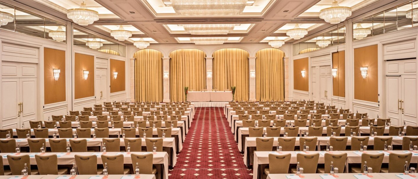 Eleganter Konferenzraum im Le Méridien Stuttgart mit Tischen, Stühlen, Kronleuchtern und goldenen Vorhängen. Perfekt für große Veranstaltungen., © Hotel Le Méridien