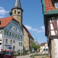 Historische Gebäude in Vaihingen Enzweihingen, darunter ein Kirchturm und Fachwerkhäuser. Ein rotes Auto parkt vor der Enztalbank. Blauer Himmel., © Land der 1000 Hügel - Kraichgau-Stromberg Historische Gebäude in Vaihingen Enzweihingen, darunter ein Kirchturm und Fachwerkhäuser. Ein rotes Auto parkt vor der Enztalbank. Blauer Himmel., © Land der 1000 Hügel - Kraichgau-Stromberg