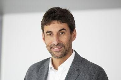 Ein Mann in einem grauen Anzug lächelt vor einem neutralen Hintergrund., © Stadt Esslingen am Neckar