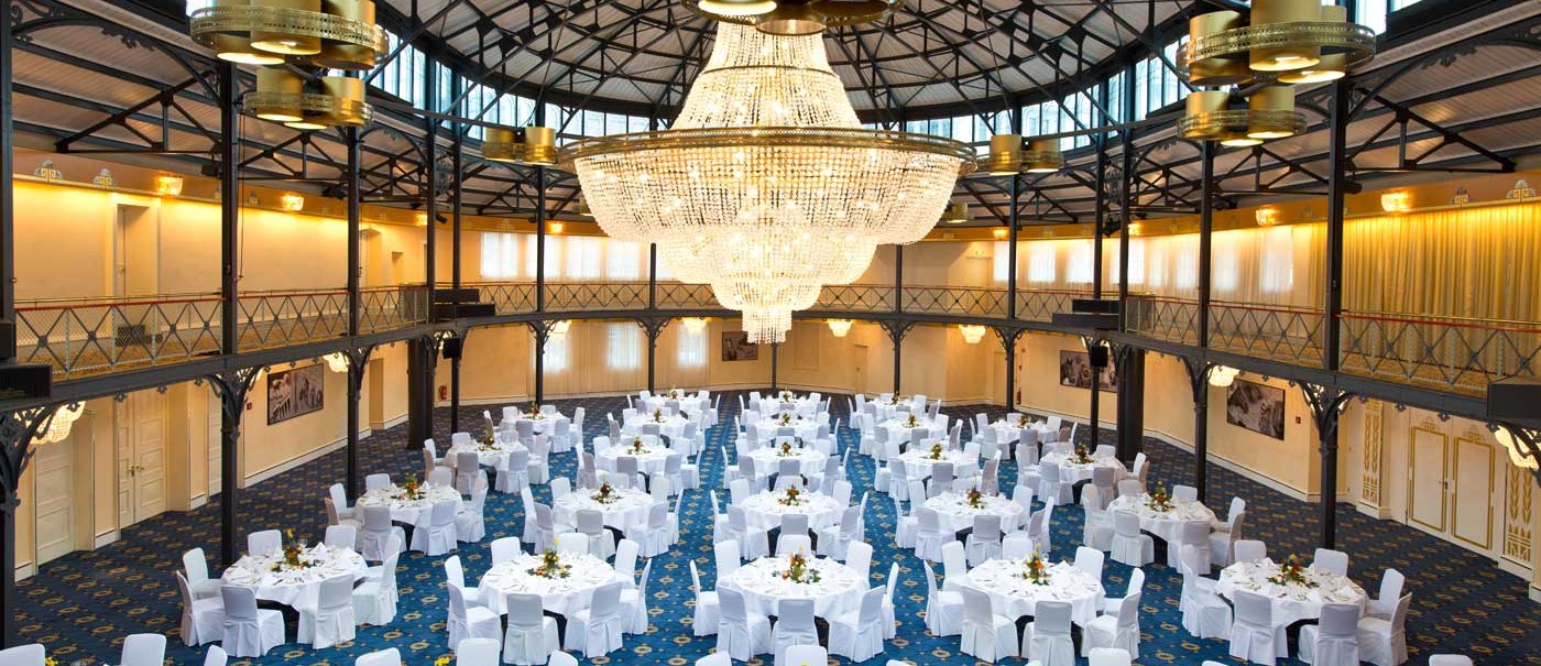 Die Alte Stuttgarter Reithalle mit elegant gedeckten Tischen und einem beeindruckenden Kronleuchter unter einem hohen, gewölbten Dach., © Maritim Hotelgesellschaft mbH
