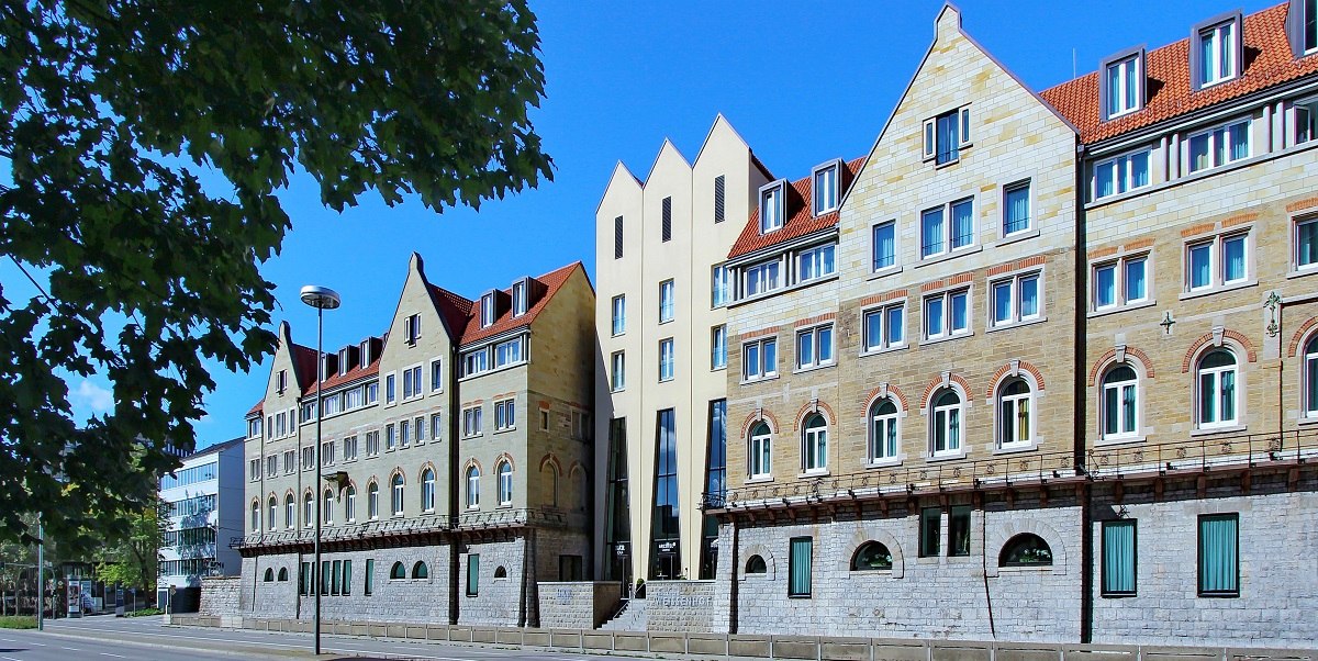 Das Arcotel Camino Stuttgart zeigt eine moderne Fassade mit traditionellen Elementen unter blauem Himmel, umgeben von B&auml;umen., &copy; Arcotel Hotels