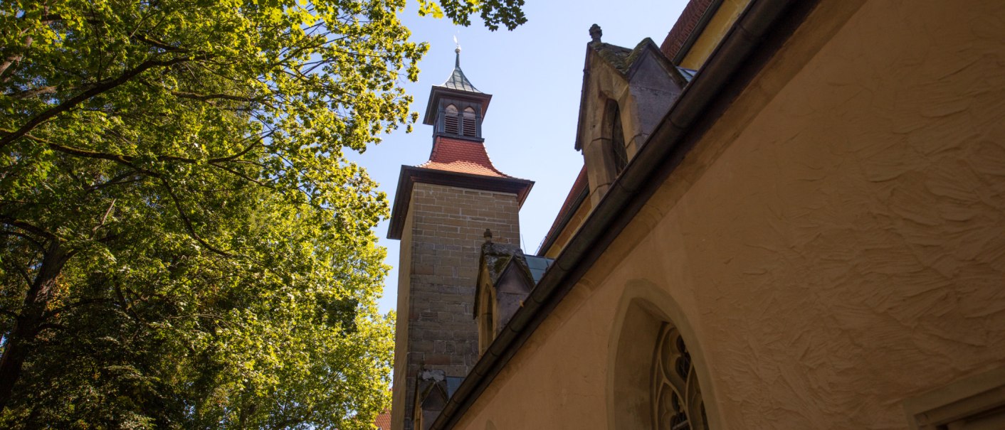 Blick auf den Turm der Schlosskirche Winnenden, umgeben von grünen Bäumen und blauem Himmel., © SMG Achim Mende