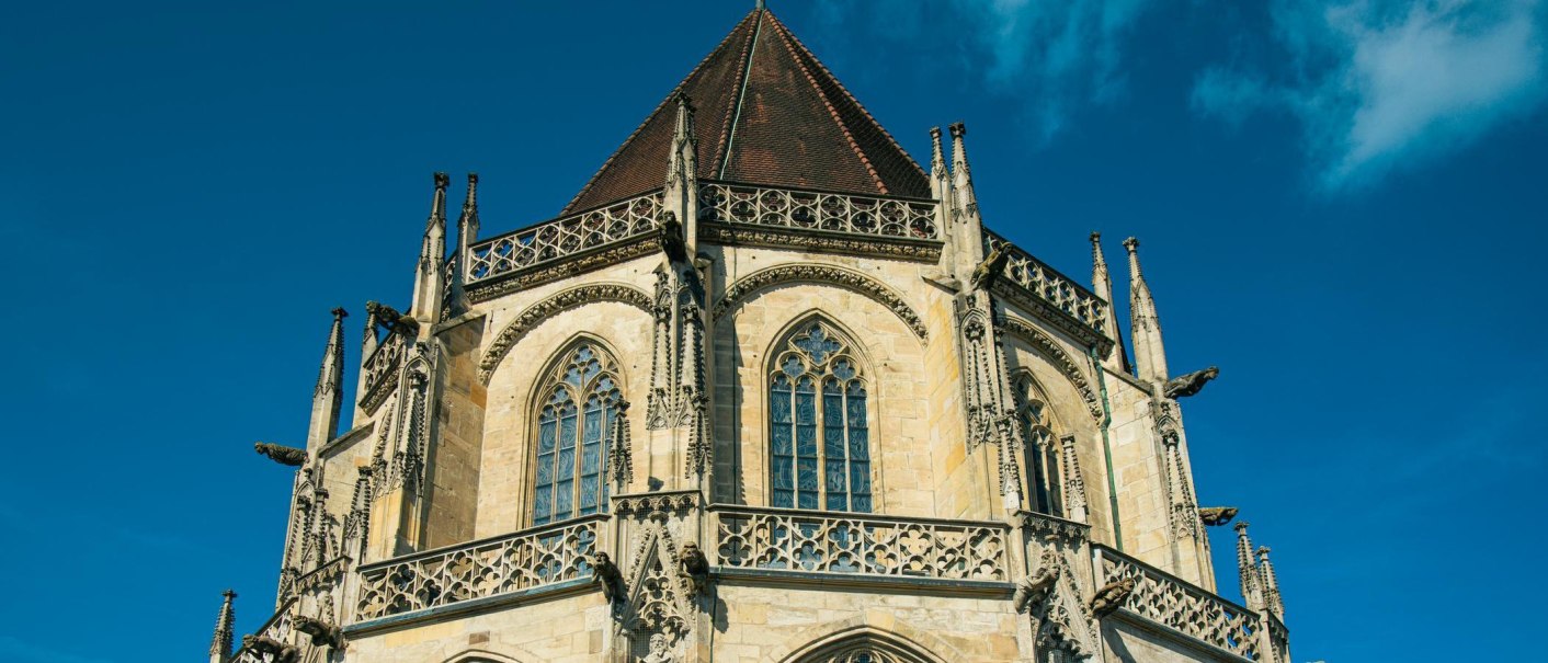 Das Heilig-Kreuz-Münster in Schwäbisch Gmünd zeigt gotische Architektur mit detaillierten Verzierungen und Fenstern unter klarem, blauem Himmel., © Stuttgart-Marketing GmbH, Sarah Schmid Das Heilig-Kreuz-Münster in Schwäbisch Gmünd zeigt gotische Architektur mit detaillierten Verzierungen und Fenstern unter klarem, blauem Himmel., © Stuttgart-Marketing GmbH, Sarah Schmid