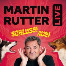 Ein Mann h&auml;lt sich die Ohren zu, w&auml;hrend zwei Hunde auf ihn zu bellen scheinen. Text: Martin R&uuml;tter Live, Schluss! Aus!, &copy; links im Bild