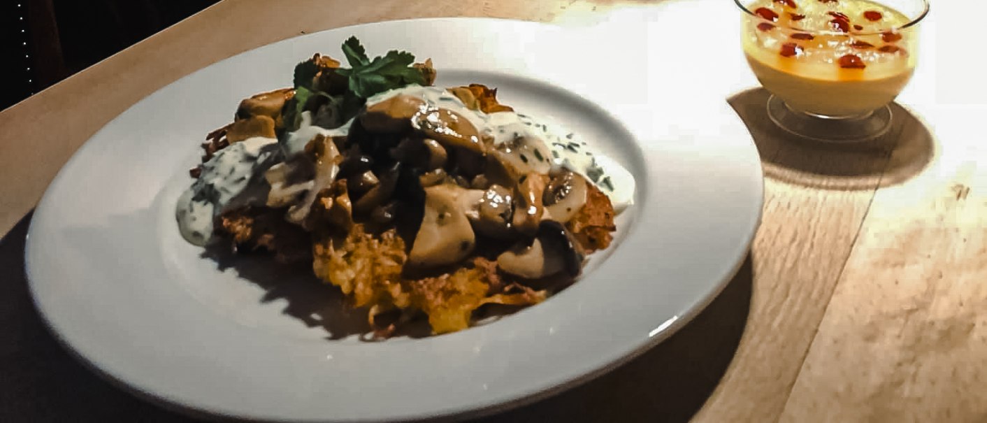 Ein Teller mit einem Gericht und ein Dessert auf einem Tisch, daneben ein Eimer mit Tulpen. Im Hintergrund ein Gemälde einer Frau., © Weinstube Fröhlich Verwaltungs GmbH Ein Teller mit einem Gericht und ein Dessert auf einem Tisch, daneben ein Eimer mit Tulpen. Im Hintergrund ein Gemälde einer Frau., © Weinstube Fröhlich Verwaltungs GmbH