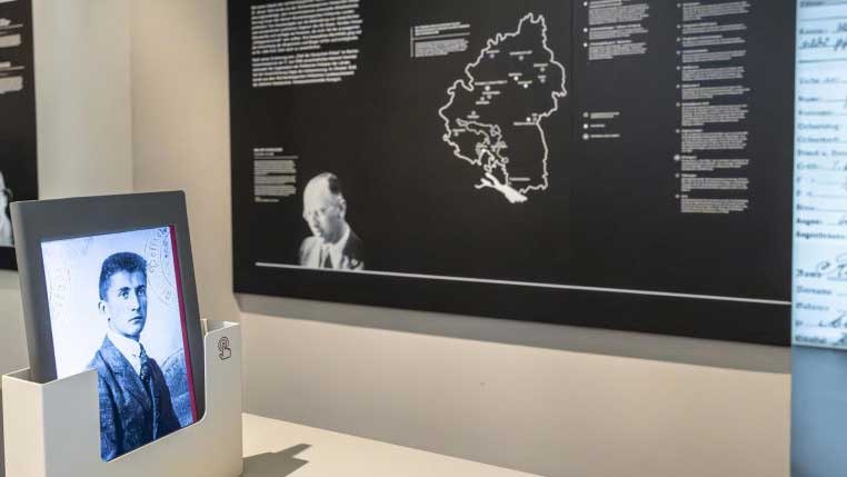 Ein historisches Foto in einem Ausstellungsraum, im Hintergrund eine Karte und Texttafeln an der Wand., © Haus der Geschichte Baden-Württemberg