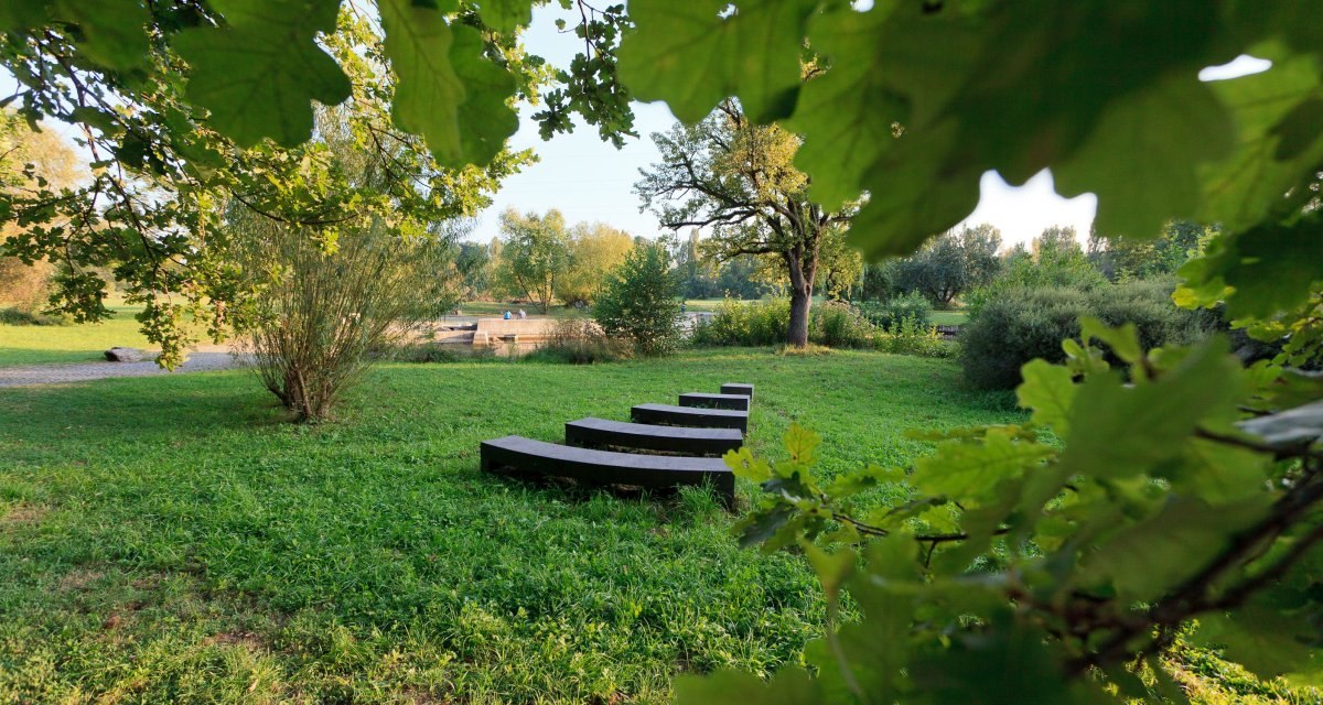 Ein grüner Park mit geschwungenen Bänken, umgeben von Bäumen und Büschen. Die Szene wirkt ruhig und einladend., © Remstal Tourismus e.V. Ein grüner Park mit geschwungenen Bänken, umgeben von Bäumen und Büschen. Die Szene wirkt ruhig und einladend., © Remstal Tourismus e.V.