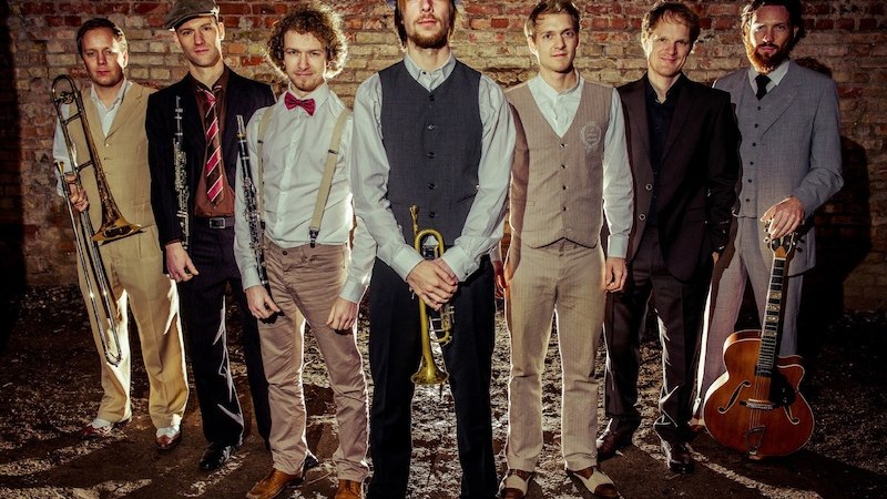 Eine Jazzband in Vintage-Kleidung posiert vor einer Backsteinwand. Die Mitglieder halten Instrumente wie Trompete und Gitarre und blicken in die Kamera., &copy; Stadt B&ouml;blingen - Amt f&uuml;r Kultur