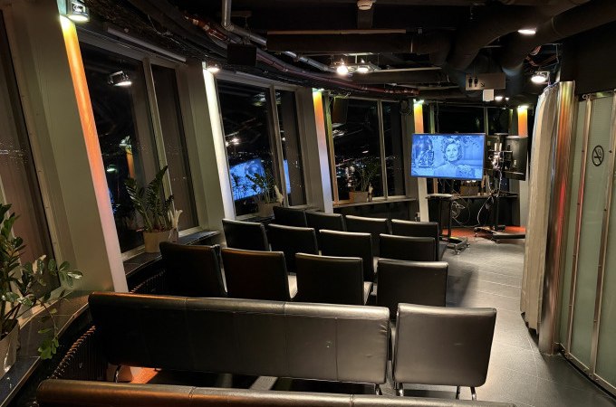 Kleiner Kinosaal mit schwarzen Ledersesseln, Pflanzen und einem Bildschirm, auf dem ein Schwarz-Weiß-Film gezeigt wird. Gemütliche Atmosphäre., © SWR Media Services GmbH / SWR Fernsehturm Stuttgart