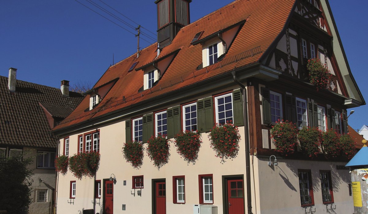 Historisches Rathaus in Ötlingen mit Fachwerk, roten Fensterläden und Blumendekorationen an den Fenstern., © Stadt Kirchheim unter Teck Historisches Rathaus in Ötlingen mit Fachwerk, roten Fensterläden und Blumendekorationen an den Fenstern., © Stadt Kirchheim unter Teck
