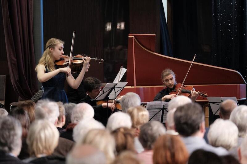 Ein Ensemble spielt Streichinstrumente vor einem aufmerksamen Publikum. Im Hintergrund steht ein Cembalo., &copy; Kulturstiftung Hohenlohe