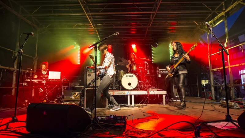 Eine Band spielt auf einer Bühne mit roter und grüner Beleuchtung. Ein Schlagzeuger, Gitarrist, Bassist und Keyboarder sind zu sehen., © Torsten Wenzler Eine Band spielt auf einer Bühne mit roter und grüner Beleuchtung. Ein Schlagzeuger, Gitarrist, Bassist und Keyboarder sind zu sehen., © Torsten Wenzler
