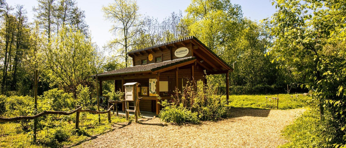 Ein kleines Holzgebäude namens 'Alvarium' steht inmitten einer grünen, bewaldeten Umgebung unter klarem Himmel., © Stuttgart-Marketing GmbH, Sarah Schmid