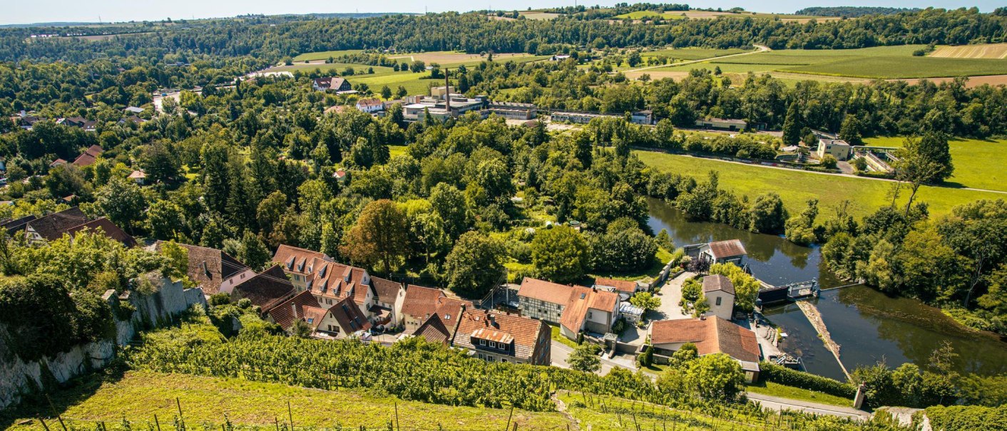 Blick auf Vaihingen an der Enz mit Schloss Kaltenstein, umgeben von grünen Wäldern und Feldern. Im Vordergrund sind Häuser und ein Fluss zu sehen., © Stuttgart-Marketing GmbH, Sarah Schmid Blick auf Vaihingen an der Enz mit Schloss Kaltenstein, umgeben von grünen Wäldern und Feldern. Im Vordergrund sind Häuser und ein Fluss zu sehen., © Stuttgart-Marketing GmbH, Sarah Schmid