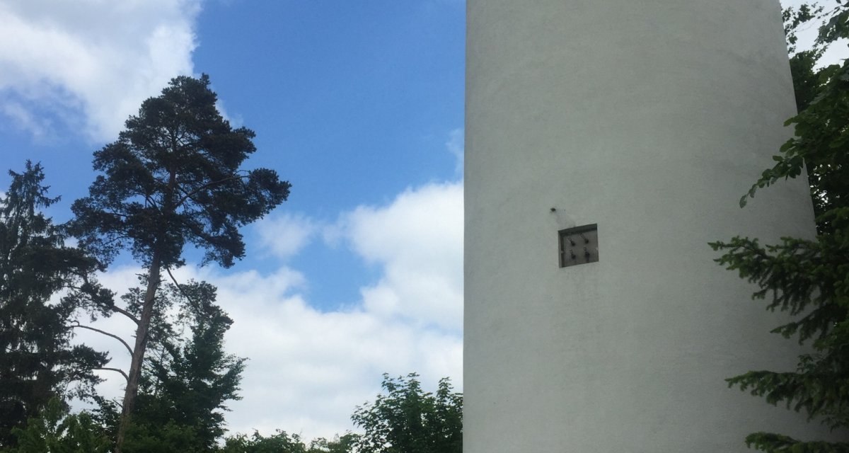 Ein weißer Turm ragt neben einem Waldstück in den blauen Himmel. Eine Bank steht am Waldrand., © www.pro-cycl.de Ein weißer Turm ragt neben einem Waldstück in den blauen Himmel. Eine Bank steht am Waldrand., © www.pro-cycl.de