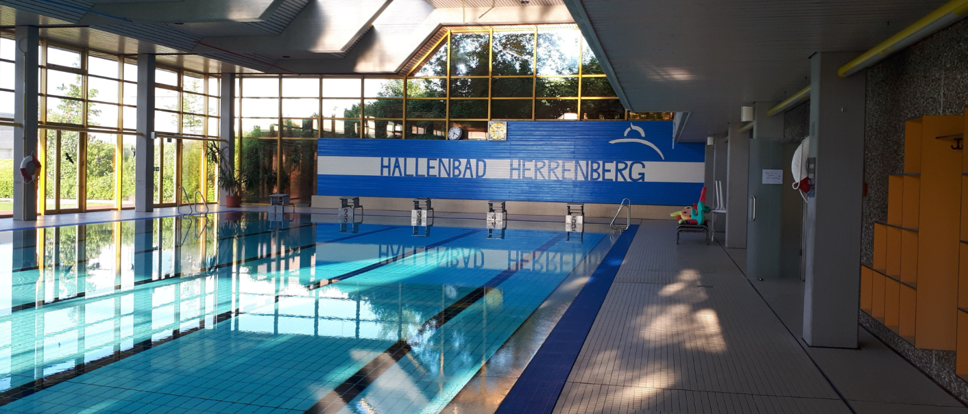Innenansicht des Hallenbads Herrenberg mit einem Schwimmbecken, Startblöcken und großen Fenstern, die viel Licht hereinlassen., © Stadtwerke Herrenberg